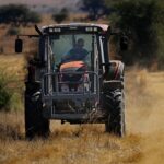 Farmer u traktoru na njivi – ilustracija radio komunikacije u poljoprivredi